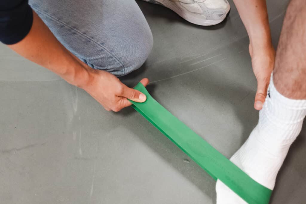 Tiemen begeleidt een patiënt tijdens fysiotherapie bij fysiosportief