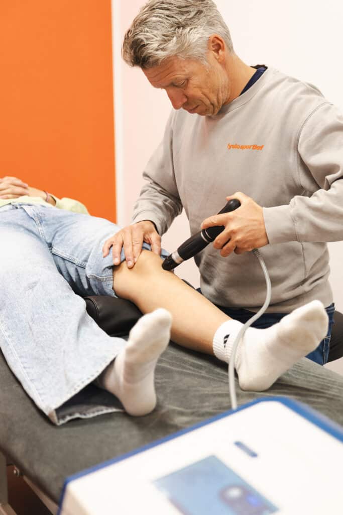 Fysiotherapeut behandelt een peesklacht met shockwave therapie
